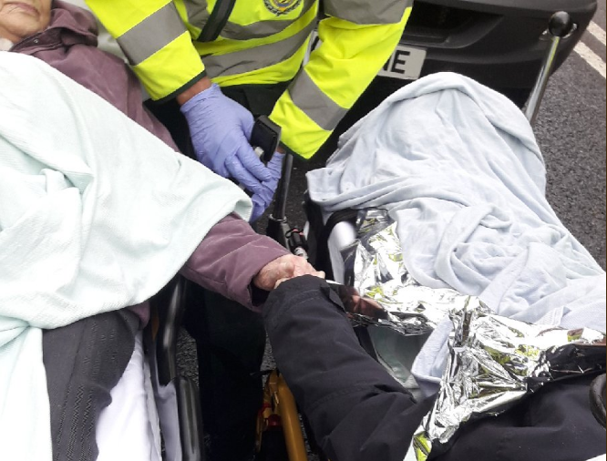 Una pareja de ancianos no suelta sus manos durante el rescate de su coche siniestrado