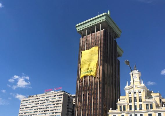 Escaladores de Greenpeace se descuelgan de un edificio de Colón para desplegar esta pancarta