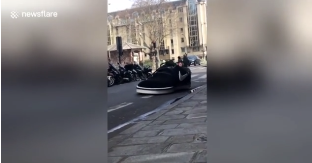 Graban un zapato gigante circulando por las calles de París