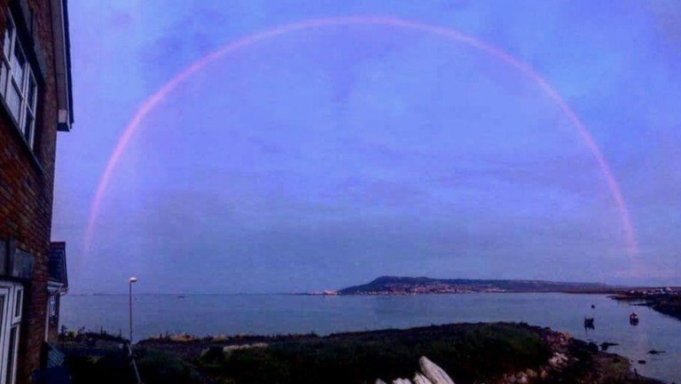 Aparece un extraño arco iris de color rosa en el cielo