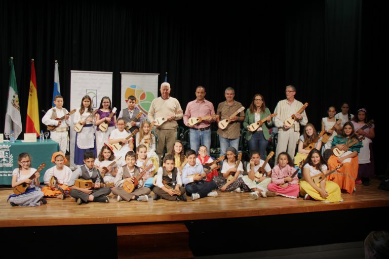 El alcalde de la Villa de Moya, Raúl Afonso, junto al coordinador de la Red de Enseñanza del Timple, Juan José Monzón, la directora del CEP Gran Canaria Noroeste, María Noelia García, y los alumnos del CEIP Villa de Firgas.